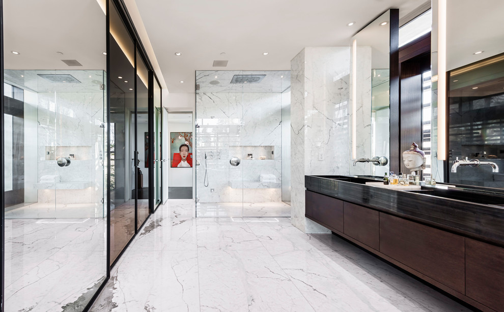 Photo of a large modern master bathroom in Vancouver with flat-panel cabinets, dark wood cabinets, a corner shower, beige walls, marble floors, an integrated sink, grey floor and a hinged shower door.