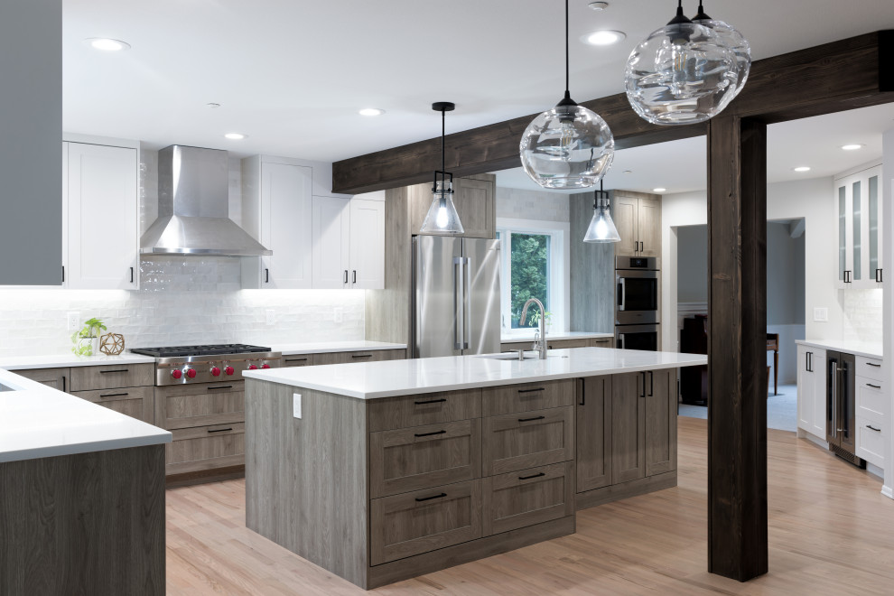 Example of a large transitional l-shaped light wood floor, beige floor and exposed beam eat-in kitchen design in Seattle with a single-bowl sink, shaker cabinets, medium tone wood cabinets, quartz countertops, white backsplash, ceramic backsplash, stainless steel appliances, an island and white countertops
