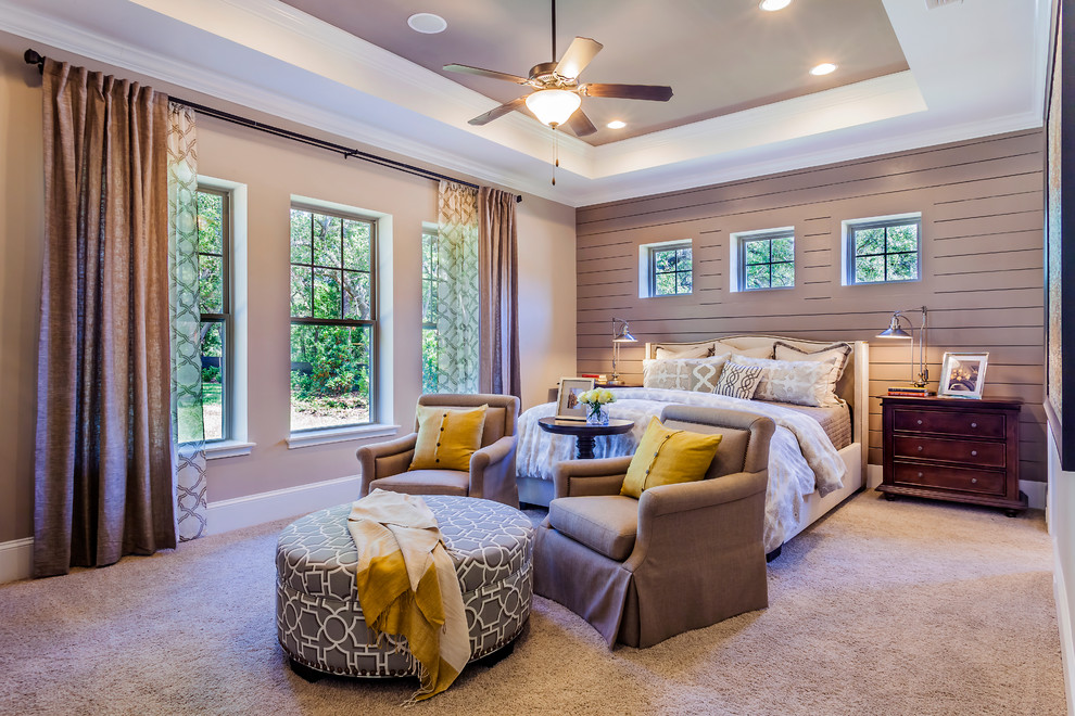 This is an example of a large transitional master bedroom in Dallas with beige walls and carpet.