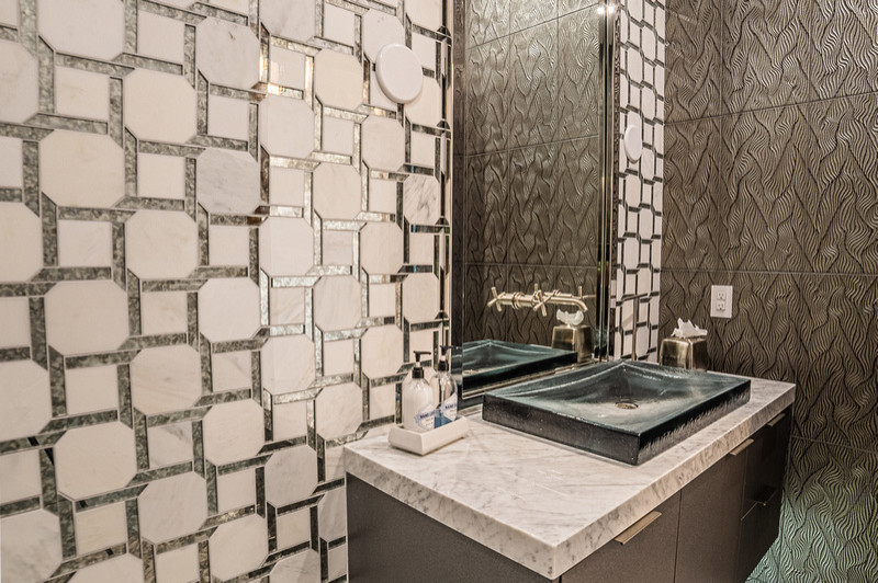 This Ascaya home remodel features contemporary elements from the moment you step foot onto the property. This powder room features custom wall treatments as well as a sleek, modern, floating vanity.