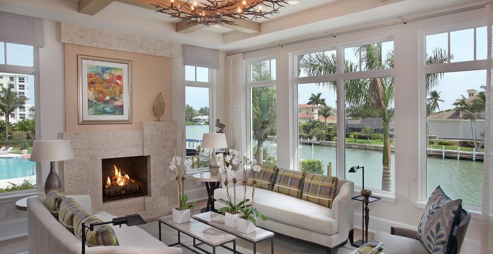 Design ideas for a large traditional open concept living room in Miami with white walls, a library and a stone fireplace surround.