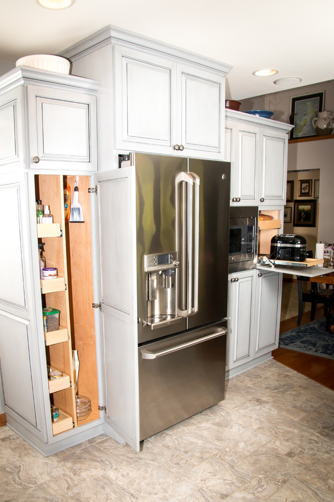 Example of a large transitional u-shaped porcelain tile and beige floor eat-in kitchen design in Milwaukee with an undermount sink, raised-panel cabinets, gray cabinets, granite countertops, white backsplash, marble backsplash, stainless steel appliances and no island