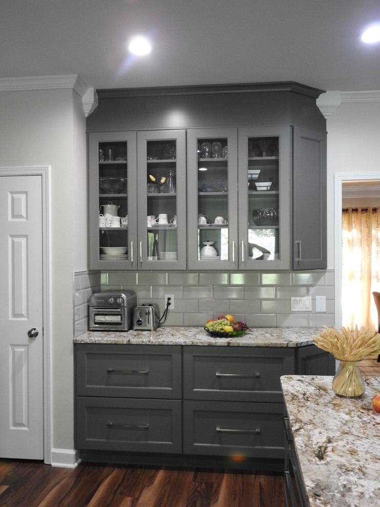 Bild på ett mellanstort funkis kök, med en rustik diskho, skåp i shakerstil, grå skåp, granitbänkskiva, vitt stänkskydd, stänkskydd i tunnelbanekakel, rostfria vitvaror, mörkt trägolv, en köksö och brunt golv