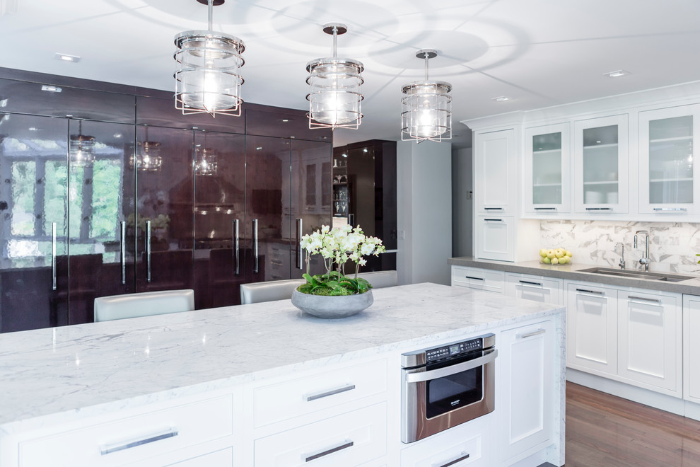 Inspiration for a large transitional galley dark wood floor eat-in kitchen remodel in Philadelphia with an undermount sink, recessed-panel cabinets, white cabinets, white backsplash, an island, quartzite countertops, ceramic backsplash and paneled appliances
