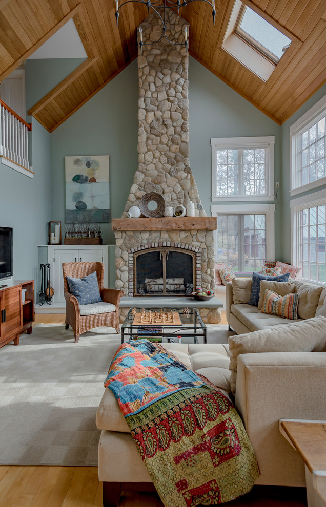 Photo of a large country formal open concept living room in Boston with light hardwood floors, a stone fireplace surround, brown floor, no tv, green walls and a wood stove.
