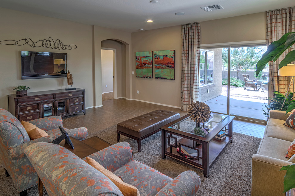 This is an example of a large open concept living room in Phoenix with beige walls, ceramic floors and a wall-mounted tv.