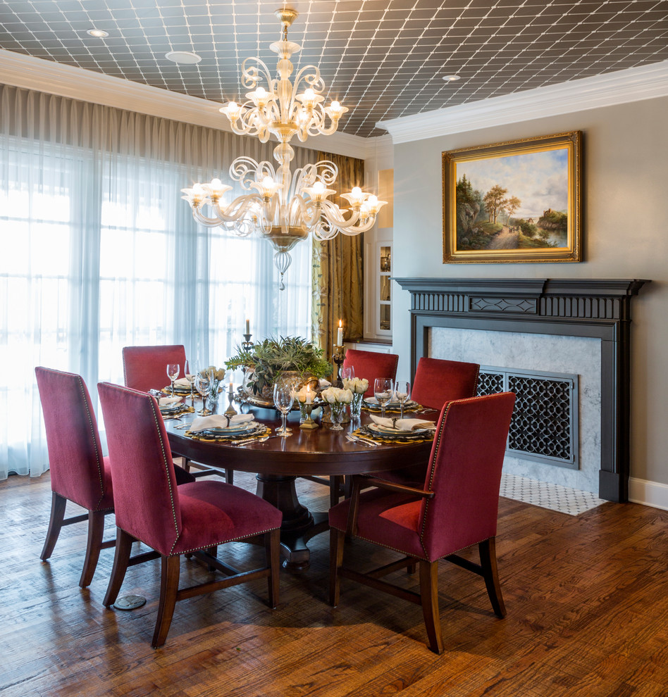Inspiration for a large traditional separate dining room in Dallas with grey walls, medium hardwood floors, a standard fireplace, a stone fireplace surround and brown floor.
