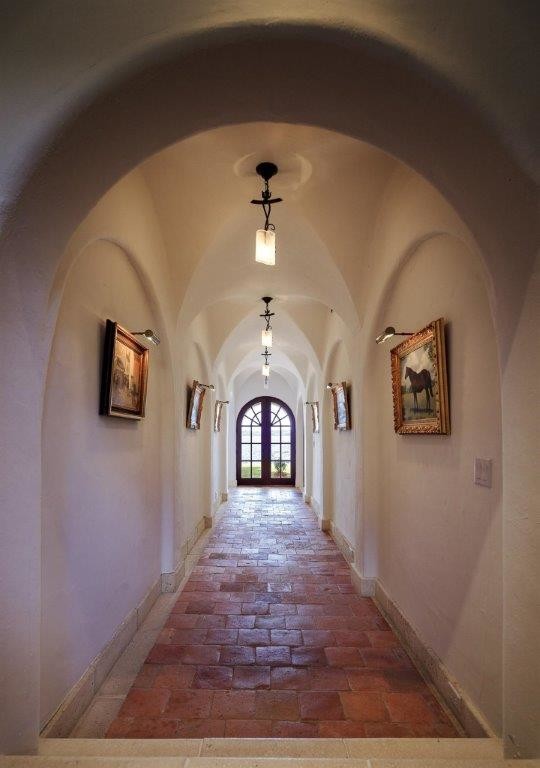 Mid-sized mediterranean hallway in Orlando with white walls and terra-cotta floors.