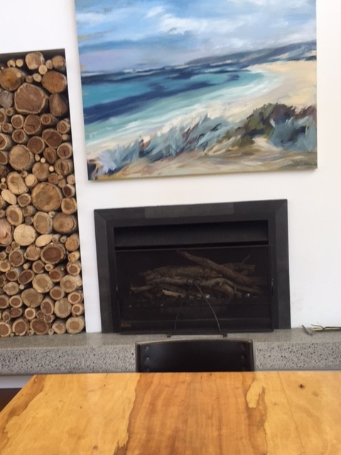 Design ideas for a beach style family room in Perth with concrete floors, a wood stove and a metal fireplace surround.
