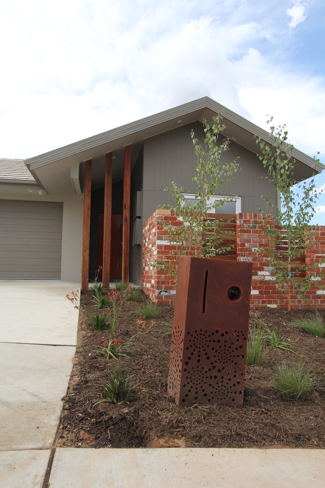 Photo of a small contemporary one-storey grey exterior in Canberra - Queanbeyan with concrete fiberboard siding.