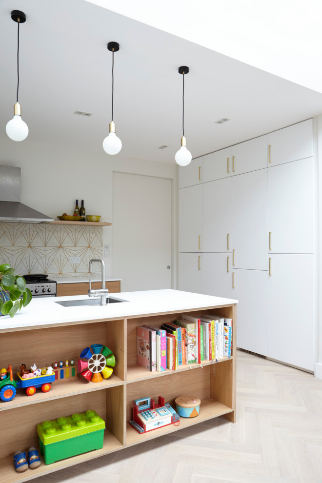 Inspiration for a mid-sized contemporary single-wall eat-in kitchen in London with an undermount sink, flat-panel cabinets, light wood cabinets, quartzite benchtops, cement tile splashback, panelled appliances, light hardwood floors, with island, white benchtop and yellow splashback.