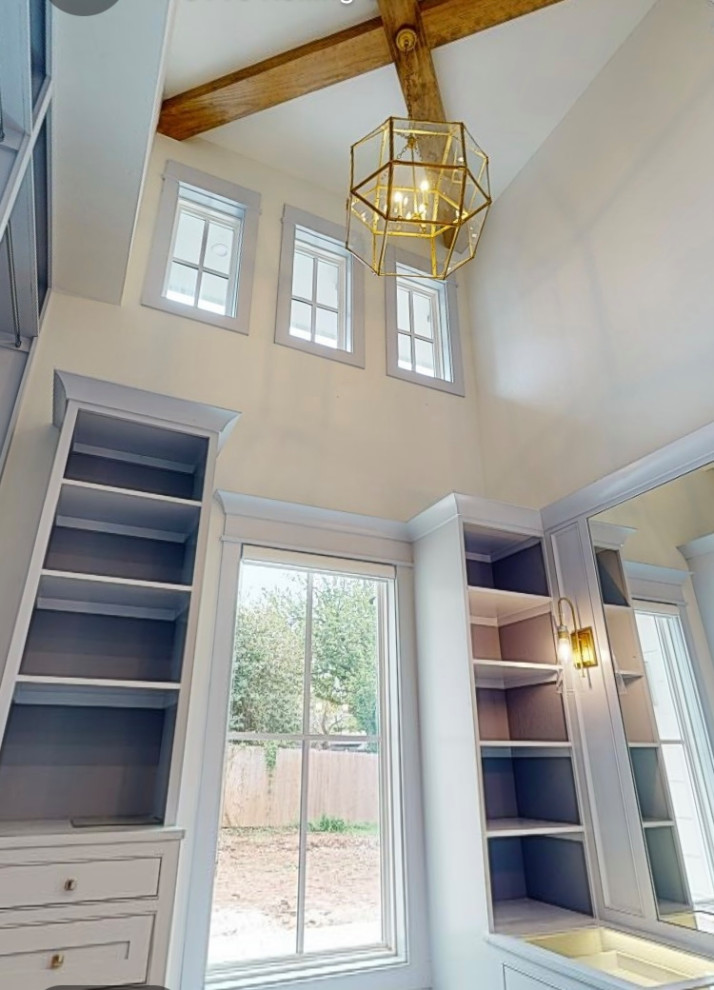 Inspiration for a large timeless women's light wood floor and exposed beam walk-in closet remodel in Oklahoma City with flat-panel cabinets and blue cabinets
