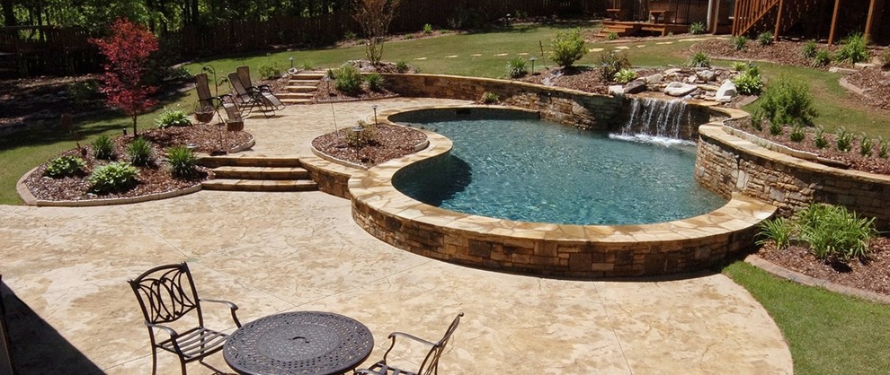 Example of a large transitional backyard stamped concrete and custom-shaped pool design in Atlanta