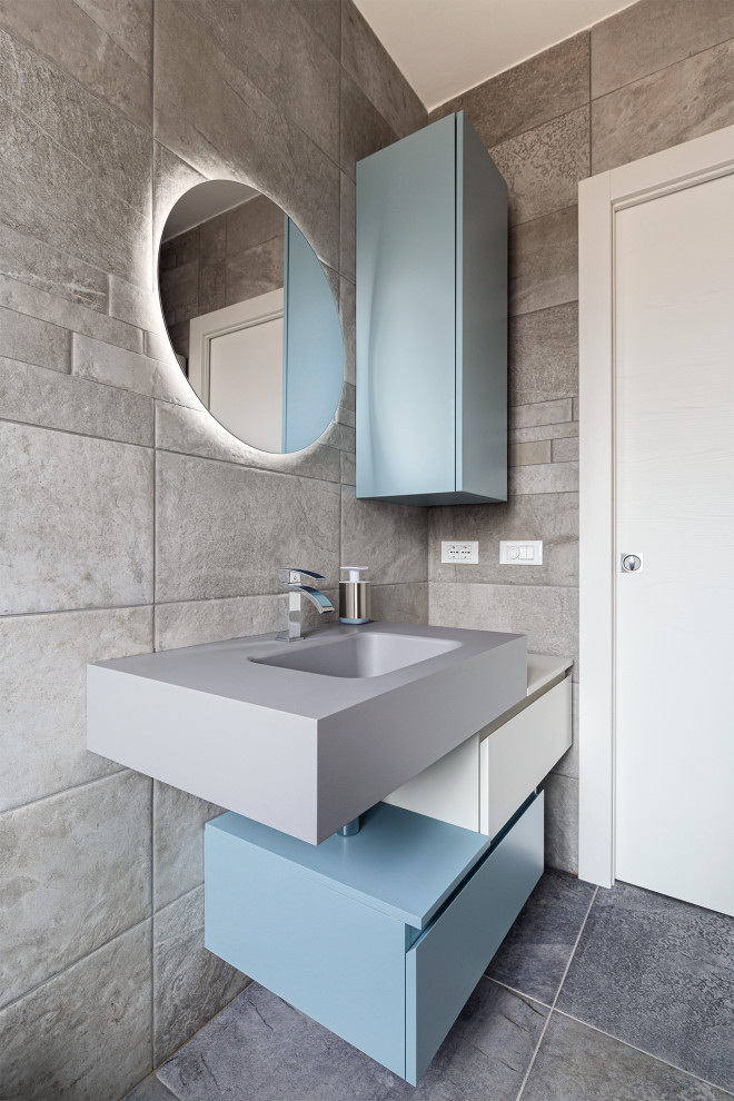 Inspiration for a large contemporary cloakroom in Other with flat-panel cabinets, turquoise cabinets, a wall mounted toilet, grey tiles, porcelain tiles, white walls, porcelain flooring, an integrated sink, laminate worktops, brown floors, beige worktops, a floating vanity unit, a drop ceiling and panelled walls.
