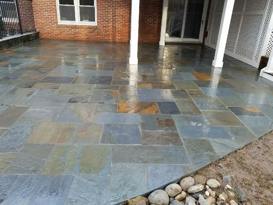 Inspiration for an expansive traditional backyard patio in Other with a water feature, natural stone pavers and no cover.
