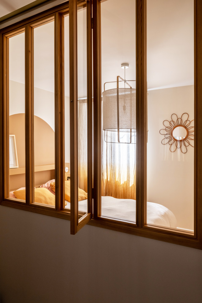 Photo of a small scandinavian master bedroom in Paris with brown walls, light hardwood floors and brown floor.