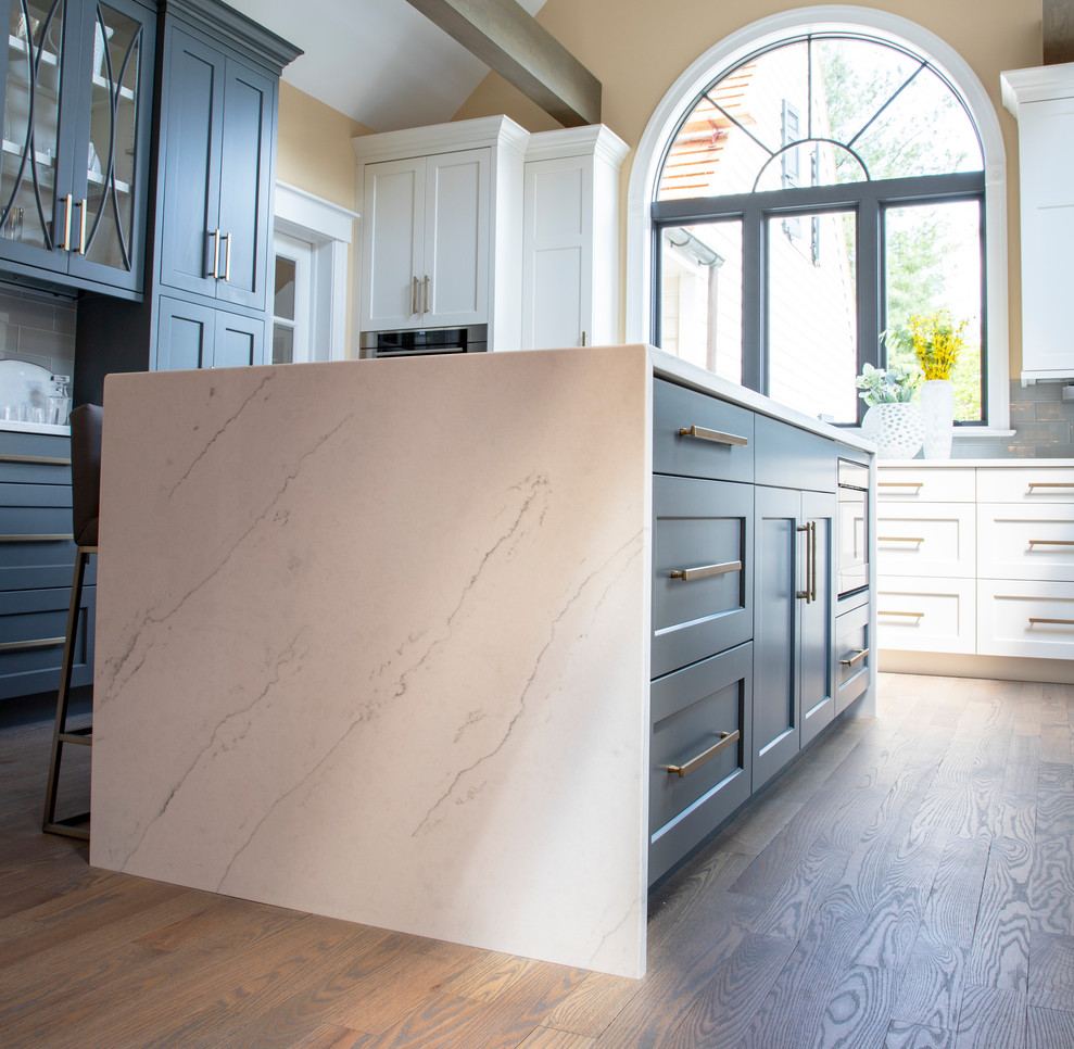Example of a large transitional u-shaped medium tone wood floor kitchen design with an undermount sink, gray cabinets, quartz countertops, gray backsplash, glass tile backsplash, paneled appliances, an island and white countertops