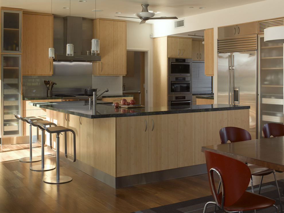 This is an example of a contemporary kitchen in San Francisco with flat-panel cabinets, light wood cabinets, metallic splashback, metal splashback and stainless steel appliances.