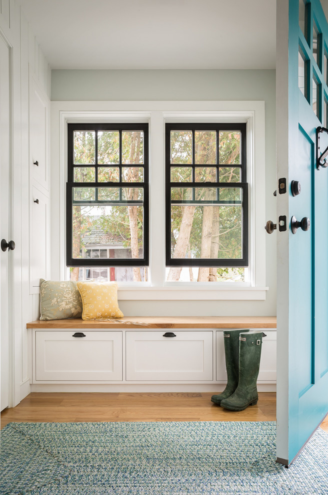 Beach style mudroom in Portland Maine with grey walls, light hardwood floors, a single front door and a blue front door.