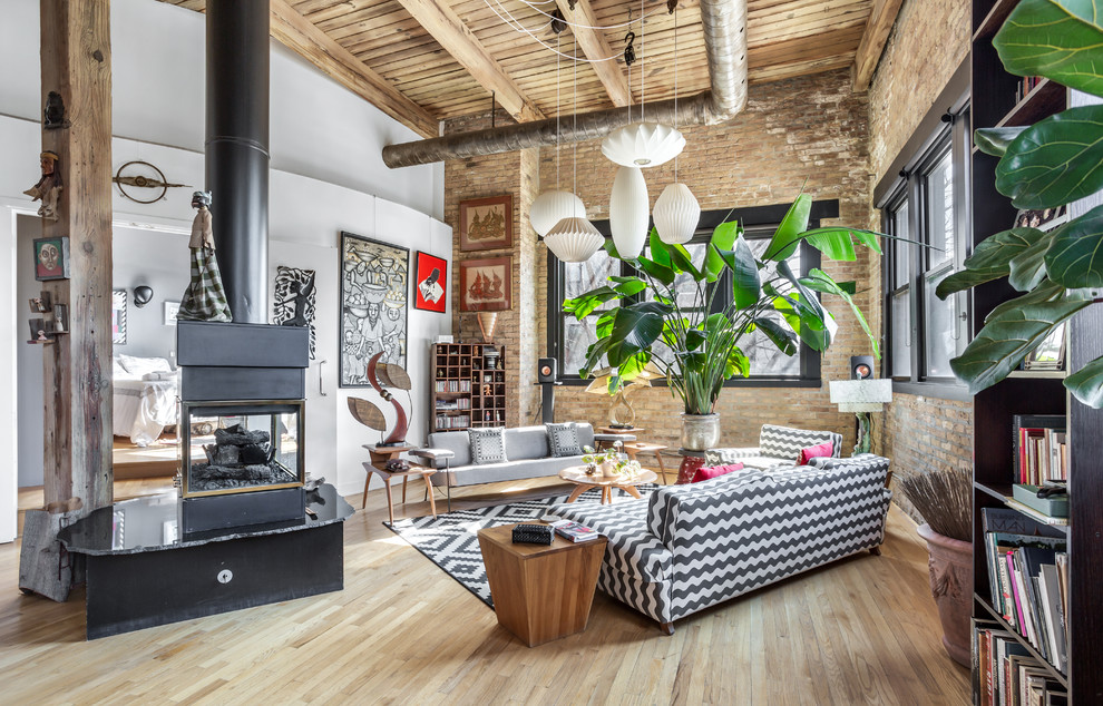 Inspiration for a mid-sized industrial formal open concept living room in Chicago with medium hardwood floors, a wood stove, a metal fireplace surround, brown floor and white walls.