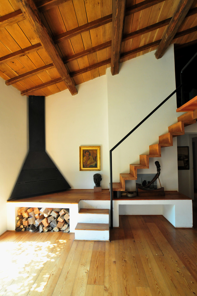 Modern wood straight staircase with wood risers and metal railing.