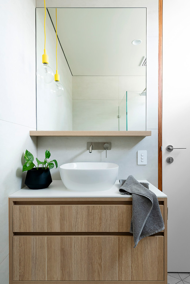 Photo of a small modern bathroom in Perth with furniture-like cabinets, light wood cabinets, a corner shower, a one-piece toilet, beige tile, ceramic tile, beige walls, ceramic floors, a vessel sink, tile benchtops, beige floor, a hinged shower door, white benchtops, a single vanity and a built-in vanity.