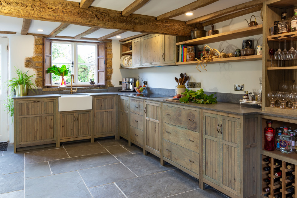 This is an example of a medium sized rustic grey and white galley kitchen/diner in West Midlands with a belfast sink, shaker cabinets, green cabinets, quartz worktops, grey splashback, engineered quartz splashback, integrated appliances, slate flooring, no island, grey floors, grey worktops, exposed beams and a chimney breast.
