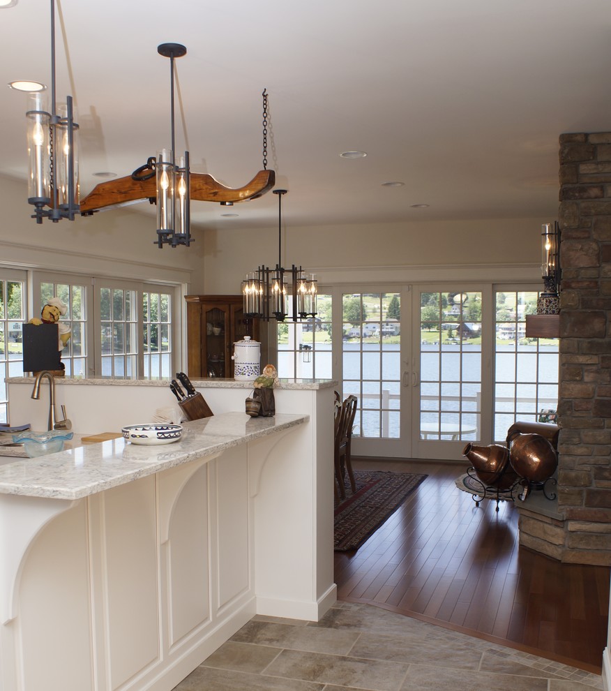Inspiration for a mid-sized transitional u-shaped porcelain tile eat-in kitchen remodel with an undermount sink, flat-panel cabinets, white cabinets, granite countertops, stone tile backsplash, stainless steel appliances, a peninsula and multicolored backsplash
