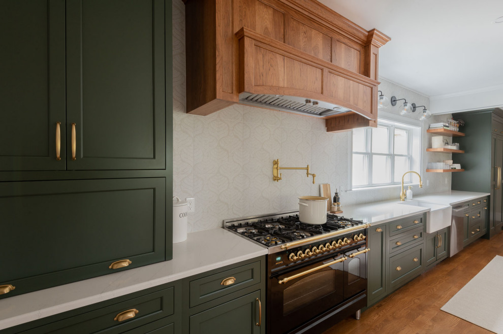 Inspiration for a huge transitional galley medium tone wood floor, brown floor and coffered ceiling eat-in kitchen remodel in Boston with a farmhouse sink, shaker cabinets, green cabinets, quartz countertops, white backsplash, ceramic backsplash, stainless steel appliances, an island and white countertops