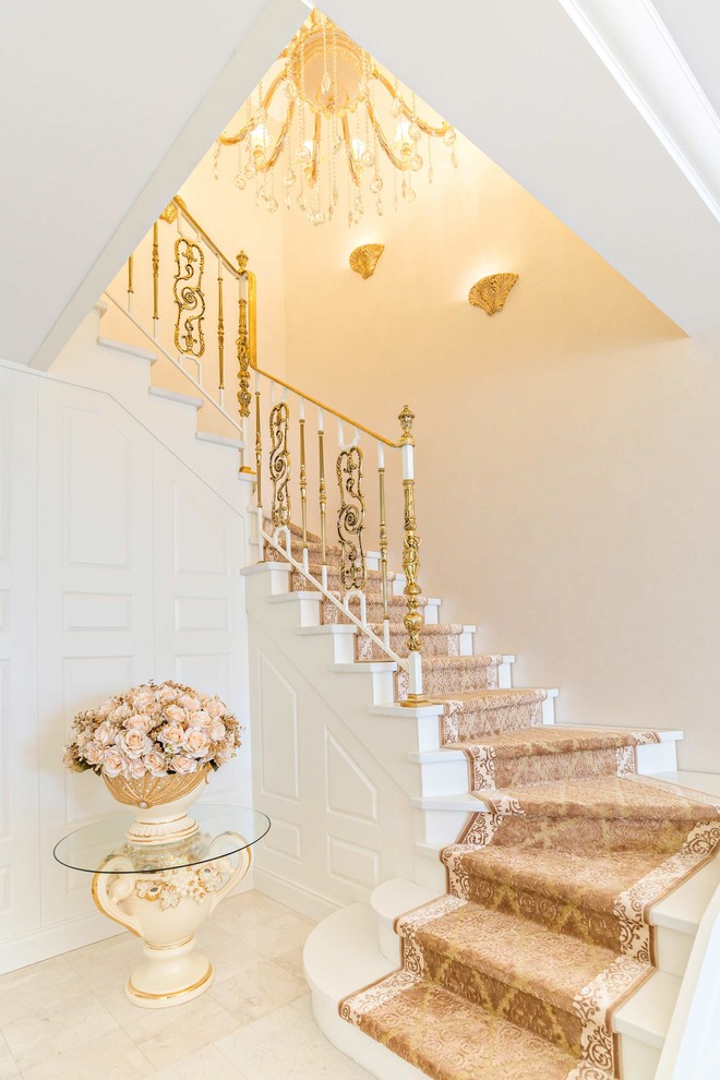 This is an example of a large traditional carpeted u-shaped staircase in Other with carpet risers and metal railing.