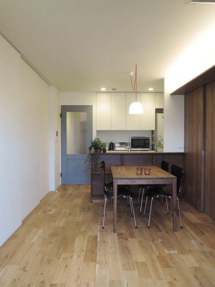 Cette image montre une salle à manger nordique avec un sol en bois brun et du papier peint.