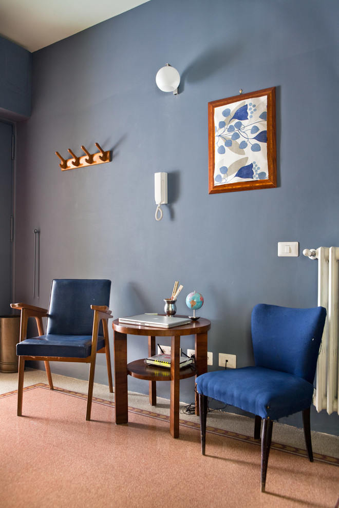 Eclectic entryway in Rome with blue walls and terrazzo floors.
