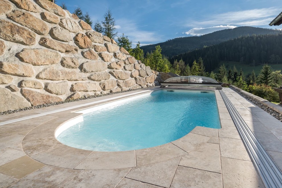 Pool - large backyard stone and custom-shaped lap pool idea in New York