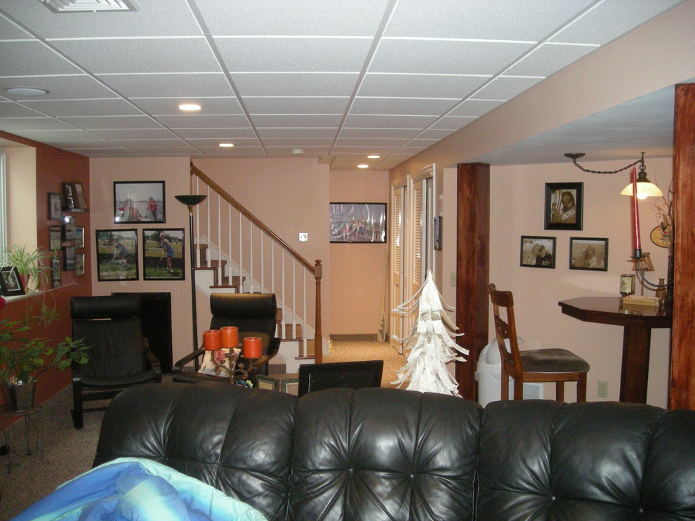 This is an example of a mid-sized traditional look-out basement in Philadelphia with orange walls, carpet and no fireplace.