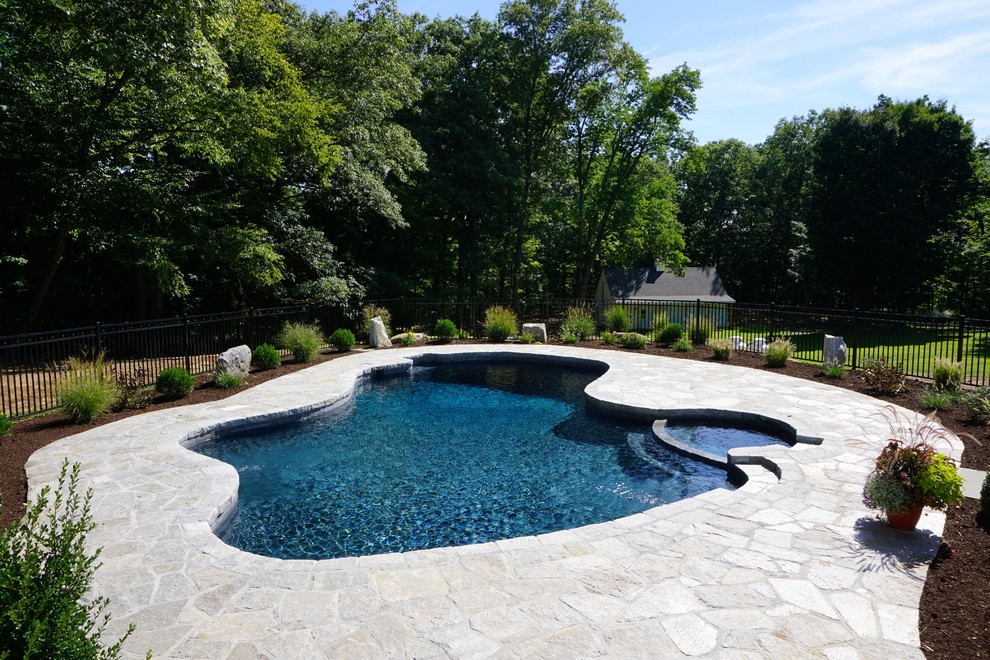 Mid-sized modern backyard custom-shaped pool in New York with natural stone pavers.