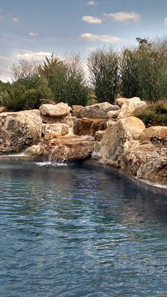 Mountain style backyard custom-shaped pool photo in New York