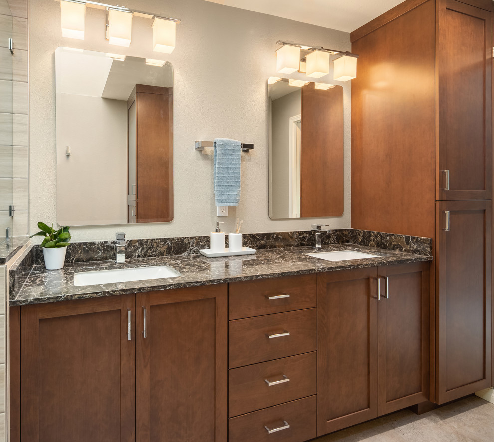 Example of a mid-sized minimalist laminate floor and double-sink corner shower design in Seattle with shaker cabinets, medium tone wood cabinets, a two-piece toilet, an undermount sink, quartz countertops, a hinged shower door, brown countertops and a built-in vanity