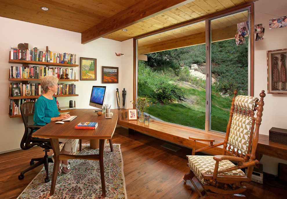 Photo of a mid-sized midcentury study room in Santa Barbara with white walls, medium hardwood floors, a freestanding desk and brown floor.