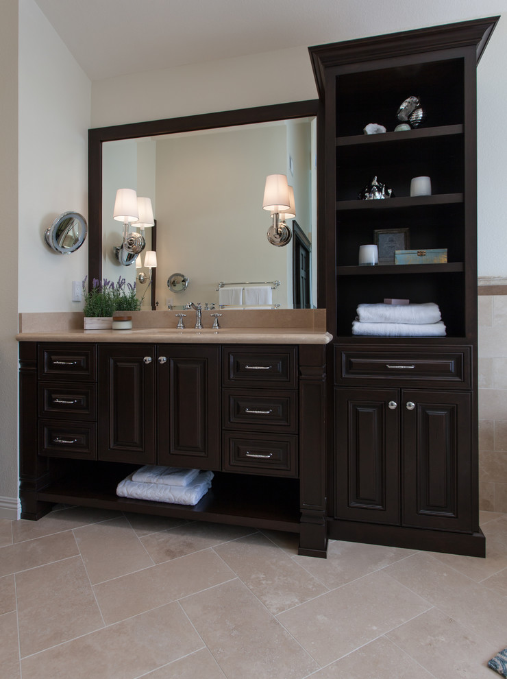 Design ideas for a large traditional master bathroom in Orange County with raised-panel cabinets, dark wood cabinets, a claw-foot tub, an alcove shower, a two-piece toilet, beige tile, stone tile, beige walls, ceramic floors, an undermount sink and solid surface benchtops.