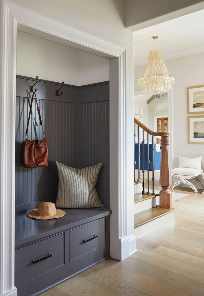 Inspiration for a large transitional light wood floor and wood ceiling mudroom remodel in Birmingham with white walls