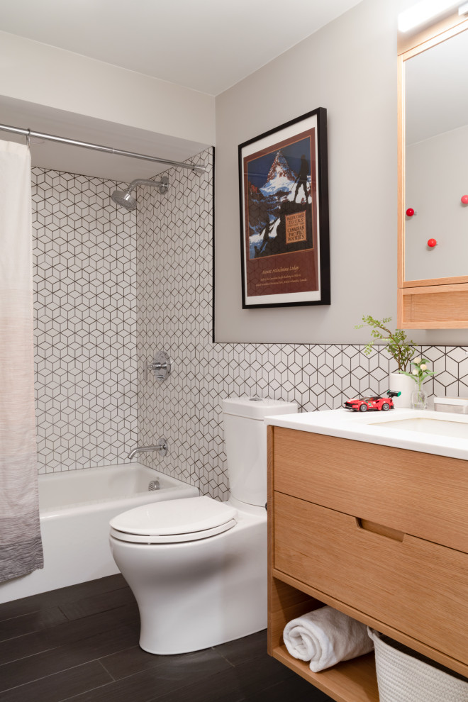 Photo of a contemporary bathroom in Boston with flat-panel cabinets, light wood cabinets, an alcove tub, a shower/bathtub combo, a two-piece toilet, white tile, grey walls, an undermount sink, brown floor, a shower curtain, white benchtops and a freestanding vanity.