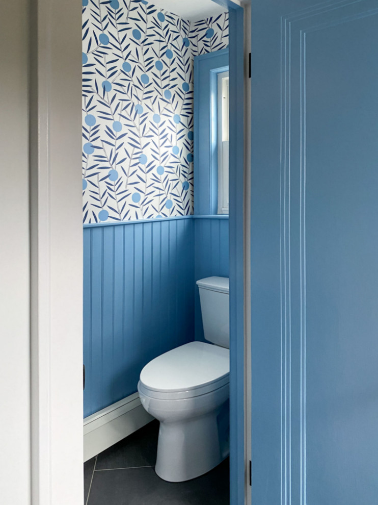 Photo of a midcentury powder room in Boston with blue walls, black floor and wallpaper.
