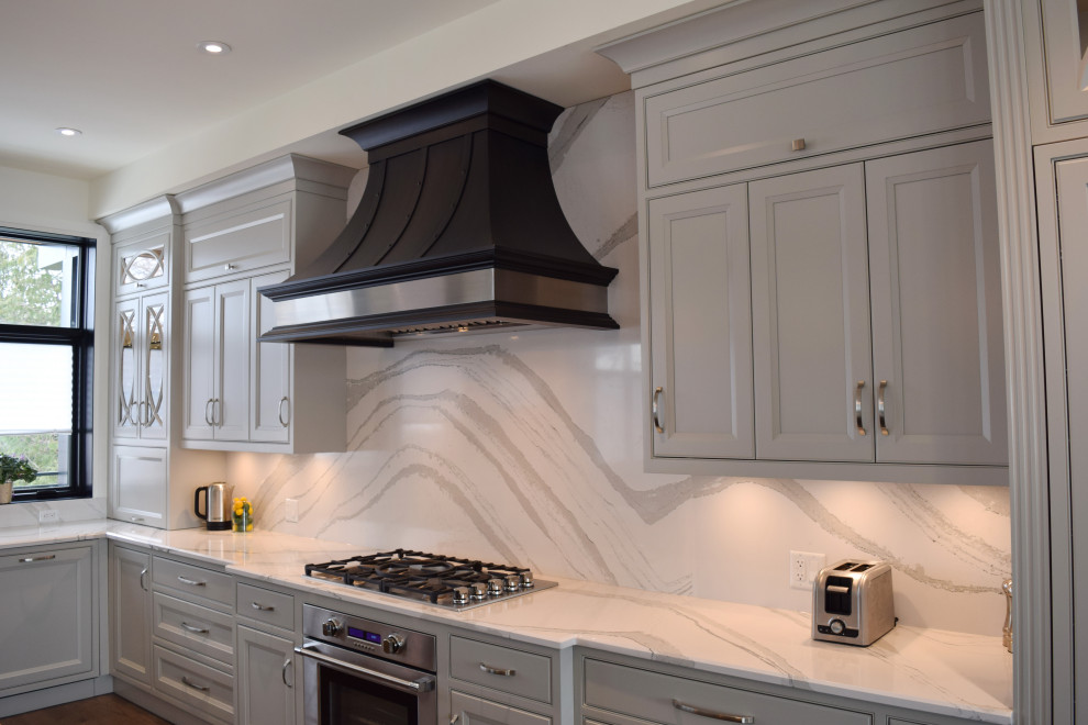 Inspiration for a large l-shaped medium tone wood floor and brown floor open concept kitchen remodel in Ottawa with an undermount sink, recessed-panel cabinets, white cabinets, quartz countertops, white backsplash, quartz backsplash, paneled appliances, an island and white countertops