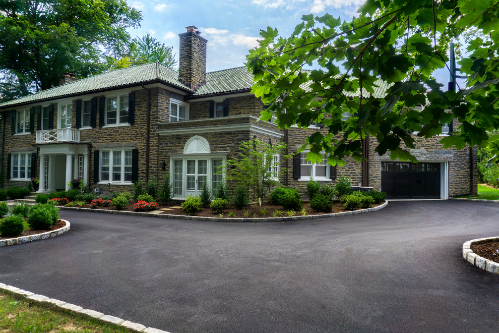 Photo of a large traditional two-storey brown exterior in Philadelphia with stone veneer and a hip roof.