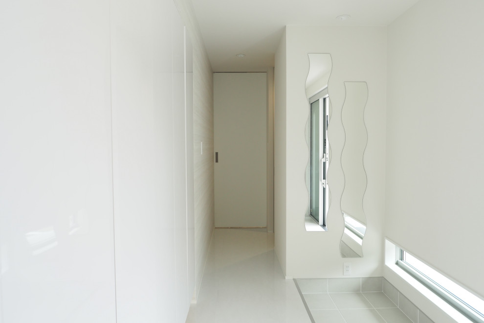 Photo of a contemporary entry hall in Other with white walls, ceramic floors, a sliding front door, a metal front door, grey floor, wallpaper and wallpaper.