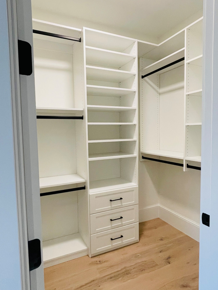 Inspiration for a mid-sized transitional gender-neutral light wood floor walk-in closet remodel in Atlanta with shaker cabinets and white cabinets
