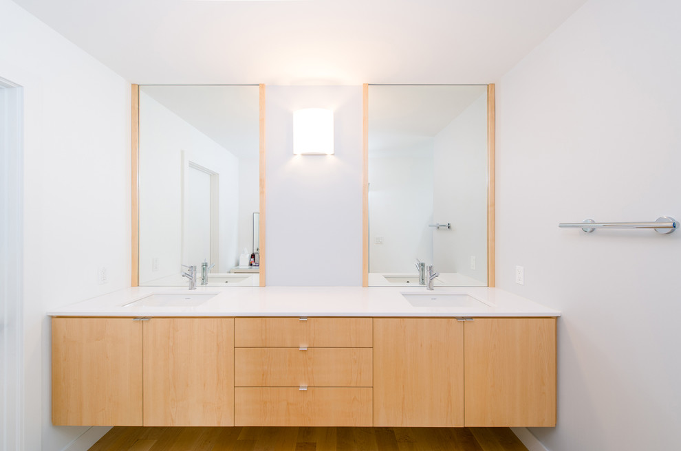 This is an example of a large contemporary master bathroom in Orange County with an undermount sink, flat-panel cabinets, light wood cabinets, engineered quartz benchtops, white walls, medium hardwood floors, a freestanding tub, white tile, porcelain tile, an open shower and a two-piece toilet.