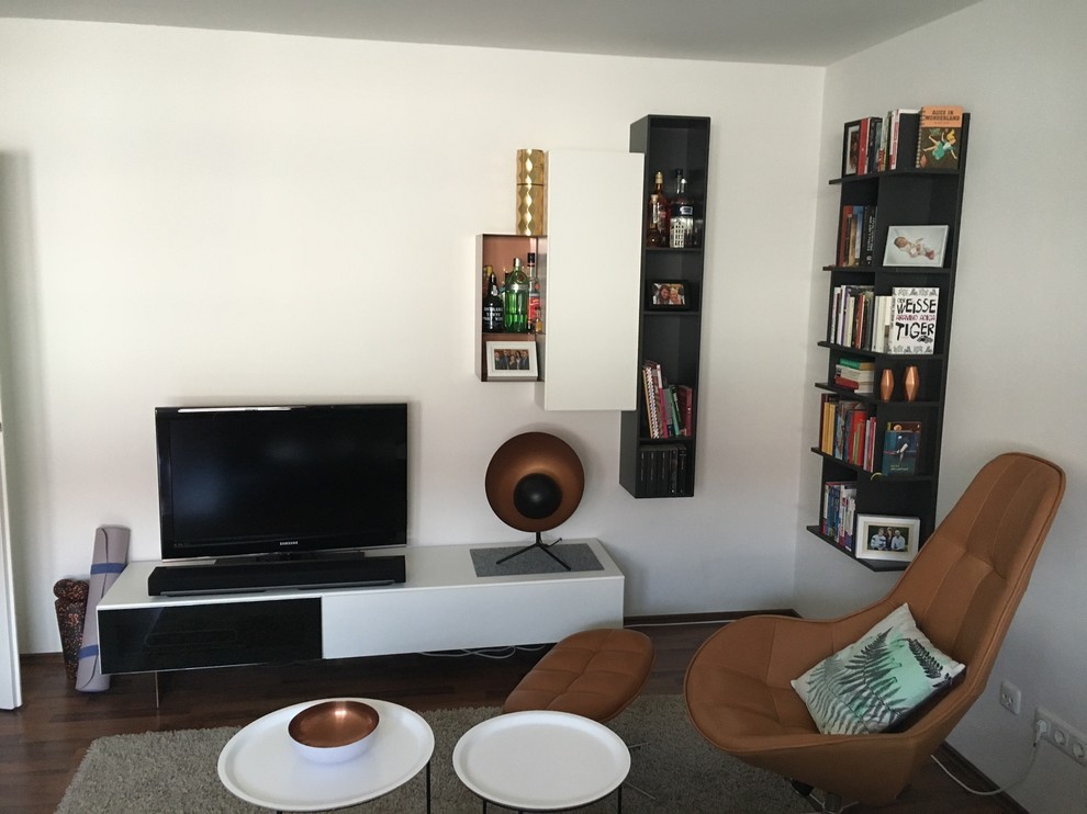 This is an example of a small scandinavian enclosed living room in Munich with white walls, slate floors and a freestanding tv.