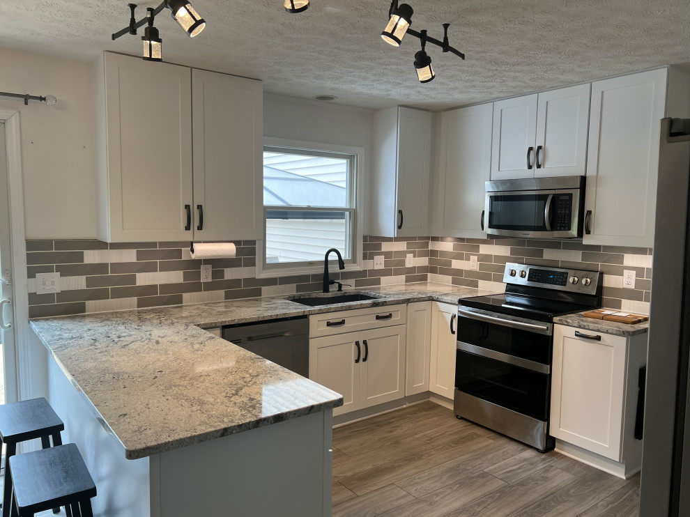 Eat-in kitchen - mid-sized traditional u-shaped eat-in kitchen idea in Cleveland with shaker cabinets, white cabinets, granite countertops and ceramic backsplash