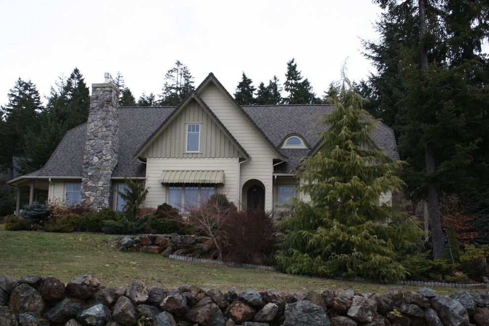 Inspiration for a mid-sized transitional multicolored two-story wood house exterior remodel with a hip roof and a shingle roof